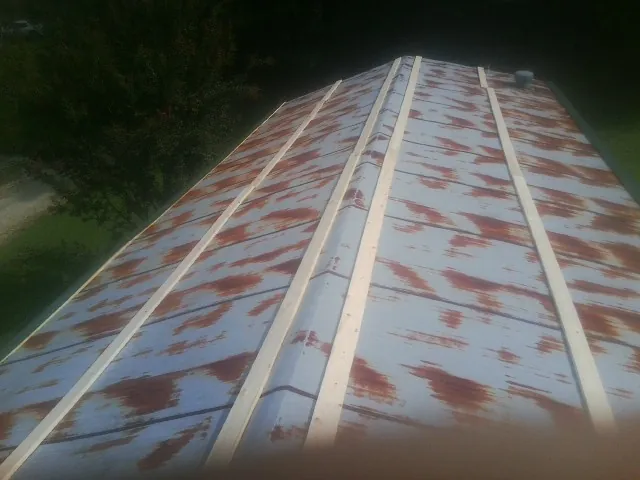 Rusted metal roof panels with new wood purlins before replacement — Storm Damage Roof Repair in Needville by Roofing Brothers
