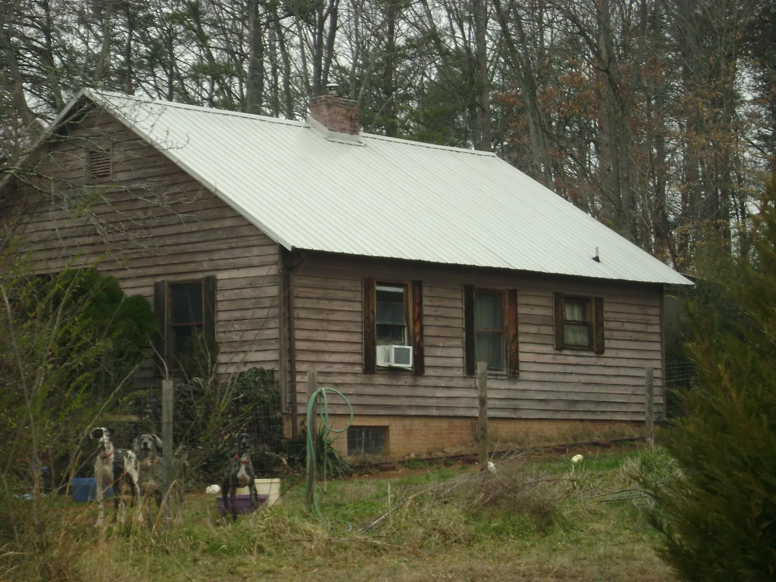 White metal roof on an old wood sided farmhouse, from a Metal Roof Installation job in Needville